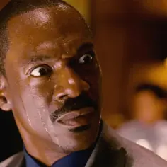 Eddie Murphy w filmach, z szeroko otwartymi oczami i spocony, wygląda na zaskoczonego.