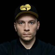 Młody mężczyzna w czapce z daszkiem Wu-Tang Clan, jeden z aktorów "Ślepnąc od świateł", patrzy prosto w obiektyw.