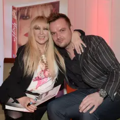 Maryla Rodowicz z mężczyzną, siedzą obok siebie, ona trzyma książkę.