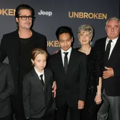 Brad Pitt z dziećmi na premierze "Niezłomnych". Aktor w okularach, obok niego synowie i starsze osoby.