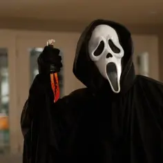 Postać w masce Ghostface z filmu Krzyk 4, trzymająca zakrwawiony nóż.