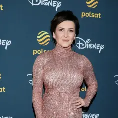 Katarzyna Łaska w błyszczącej sukni, z napisem "Mam tę moc" w tle.