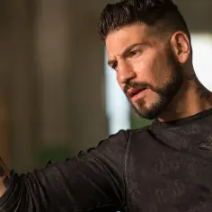 Jon Bernthal z tatuażami na ręce i szyi, w ciemnej koszulce z czaszką. Wiele jego filmów i seriali to hity.