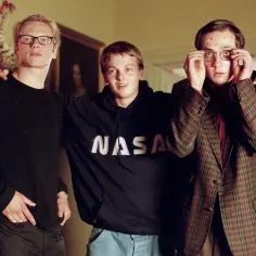 Chłopaki nie płaczą obsada: trzech młodych mężczyzn w okularach, jeden w bluzie NASA, drugi w marynarce w kratę, trzeci w czarnym swetrze.
