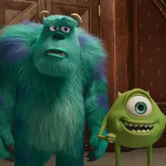 Sully i Mike, bohaterowie bajek z dzieciństwa, stoją obok siebie. Jeden jest duży i futrzasty, drugi małe i zielone.
