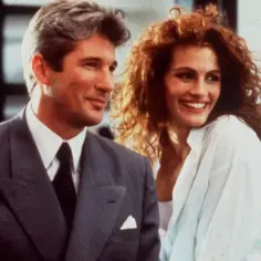 Uśmiechnięta, **pretty woman** w białej koszuli obok eleganckiego mężczyzny w garniturze.