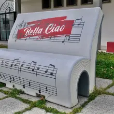Ławka w kształcie książki z nutami i napisem "Bella Ciao tekst".