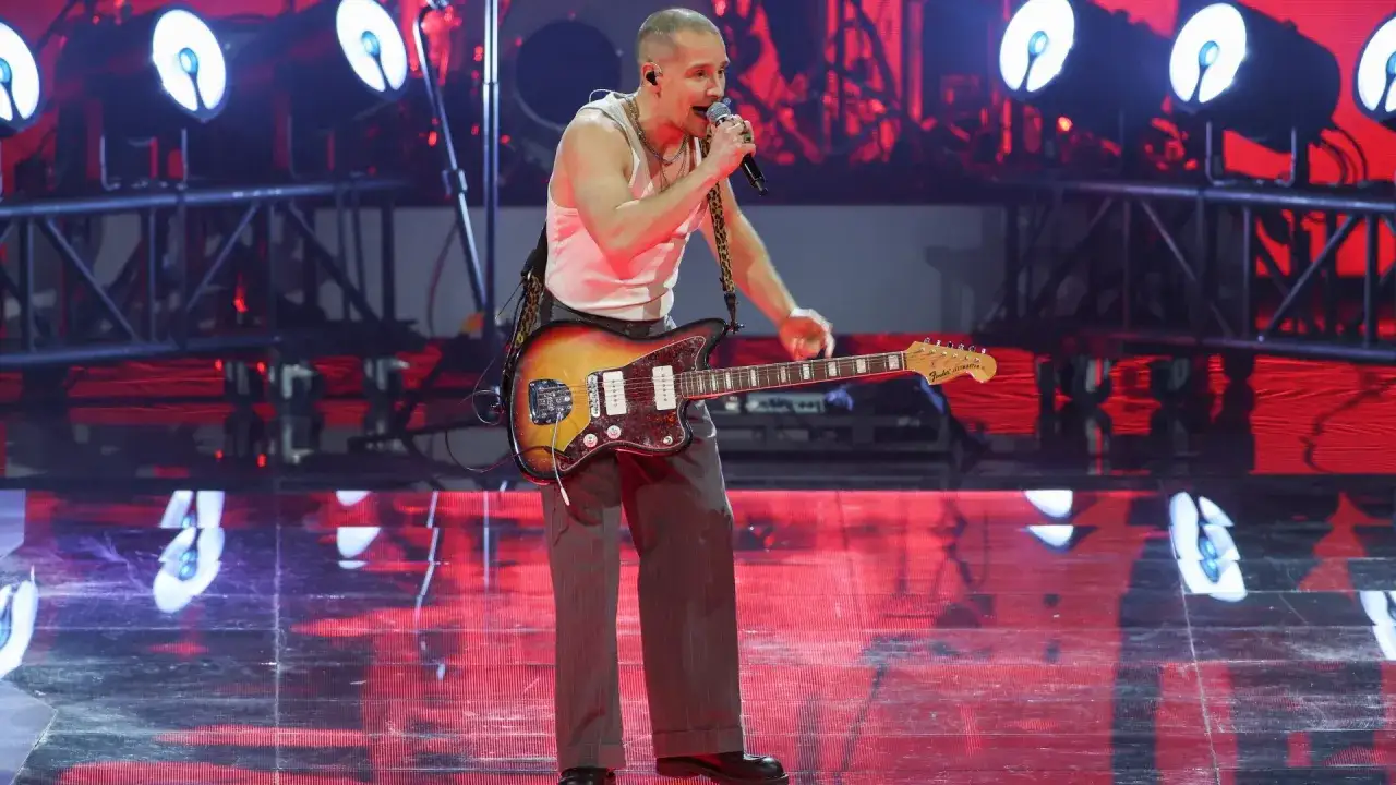Krzysztof Zalewski na scenie, śpiewając i grając na gitarze. Jego utwory poruszają tłumy.
