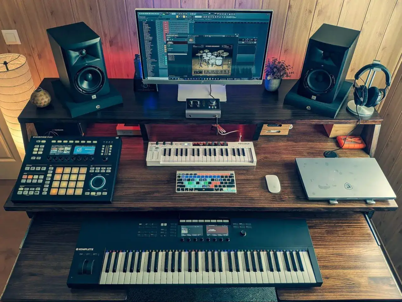Studio do tworzenia muzyki, gdzie każdy dźwięk to pułapka dla uszu. Monitory, klawiatury, kontrolery i laptop tworzą idealne miejsce do produkcji trap.