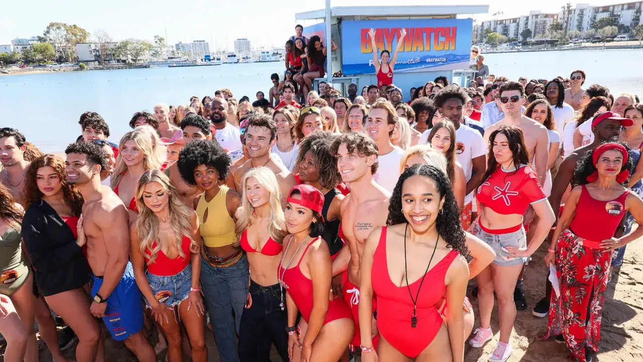 Słoneczny patrol obsada na plaży, w tle napis BAYWATCH.