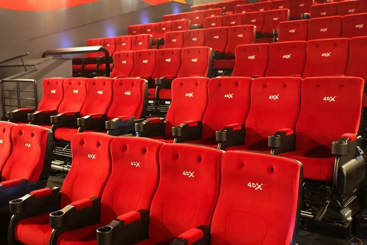 Czerwone fotele kinowe z napisem 4DX, gotowe na wciągające doświadczenie filmowe.