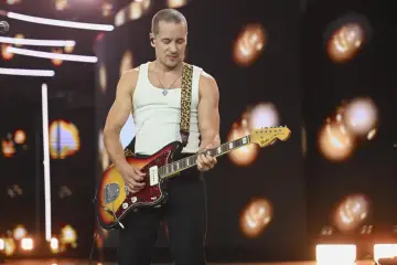 Krzysztof Zalewski gra na gitarze podczas koncertu, prezentując swoje utwory.