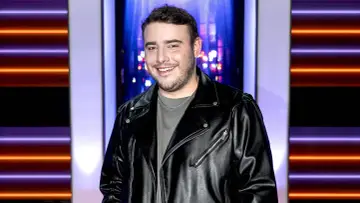 Krystian Ochman w skórzanej kurtce, uśmiechnięty. Choć na zdjęciu nie ma jego żony, jego spojrzenie sugeruje, że myśli o niej.