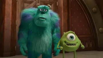 Sully i Mike, bohaterowie bajek z dzieciństwa, stoją obok siebie. Jeden jest duży i futrzasty, drugi małe i zielone.