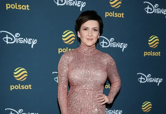 Katarzyna Łaska w błyszczącej sukni, z napisem "Mam tę moc" w tle.
